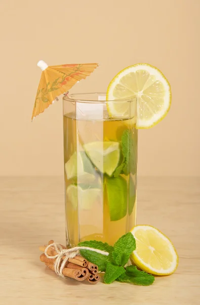 Drink glass, slice of a lemon and cinnamon stick on a table — Stock Photo, Image