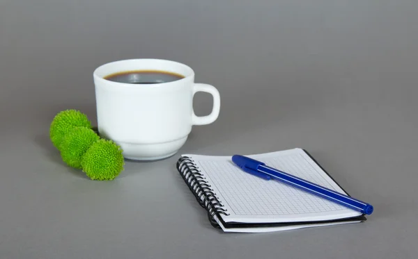 Una taza de café aromático, crisantemos verdes, un bloc de bocetos y un bolígrafo —  Fotos de Stock