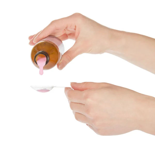 Руки залить розовое лекарство в ложку изолированы на белом — стоковое фото