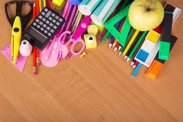 Serie di strumenti di ufficio lucenti, libri di esercizi e mela su un tavolo — Foto Stock