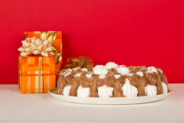 The gift boxes decorated with bow and a pie on a white cloth, on the red — Stock Photo, Image