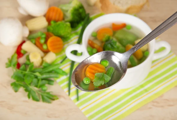 Soup in a spoon a set of vegetables and mushrooms on a table — Stock Photo, Image