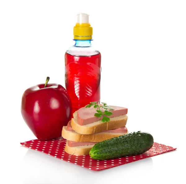 Sandwiches, parsley, cucumber, red apple and bottle with compote, on napkin — Stock Photo, Image