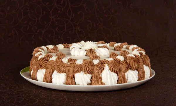 Iştah açıcı bir pasta üzerinde kahverengi bir bez ile çanak — Stok fotoğraf