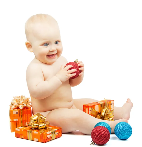 Rapt enfant tient boule de Noël rouge, boîtes de fête, boules rouges et bleues colorées isolées sur blanc — Photo