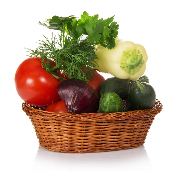 Cucumbers, tomatoes, red onions, pepper and greens in the basket isolated on white — Stock Photo, Image