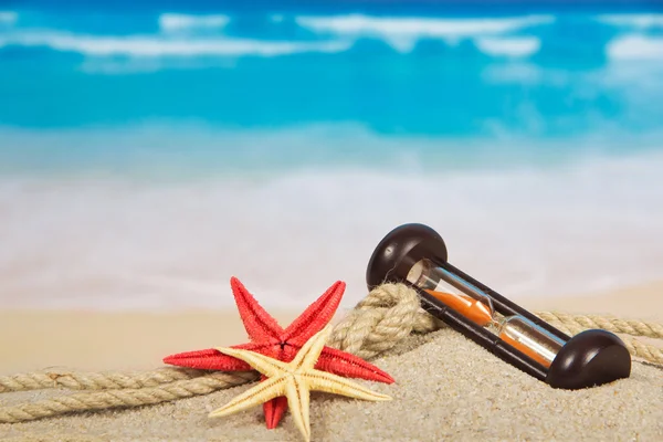 Hourglasses, starfishes on the sea coast — Stock Photo, Image