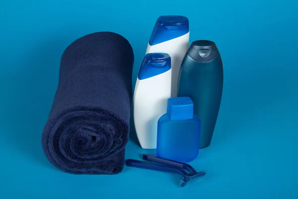 The razor, lotion, shampoo and towel, on the blue — Stock Photo, Image