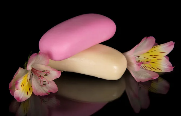 Belle fleur d'un alstroemeria et deux morceaux de savon, isolé sur noir — Photo