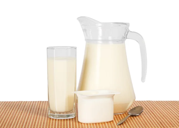 Krug und Glas mit Milch, Joghurt auf Bambustuch, isoliert auf weiß. — Stockfoto