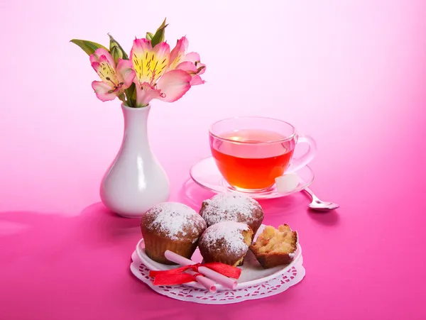 Kekler pembe bir arka plan üzerinde bir kahvaltıda çay — Stok fotoğraf