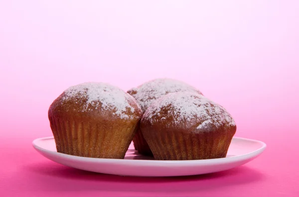 Cupcake op een schotel op een roze achtergrond — Stockfoto