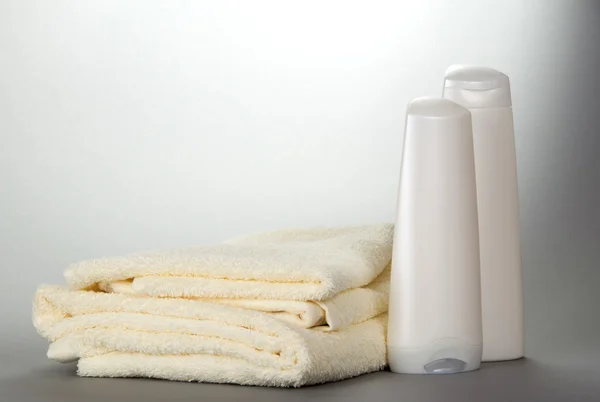 Terry towels and cosmetics set for a shower on a gray background — Stock Photo, Image