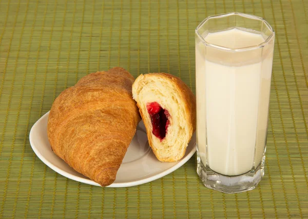 Glas melk en croissants op een bamboe servet — Stockfoto