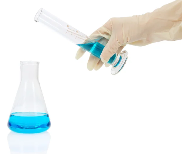 The flask with blue liquid, a hand holds a measured tube isolated on white — Stock Photo, Image