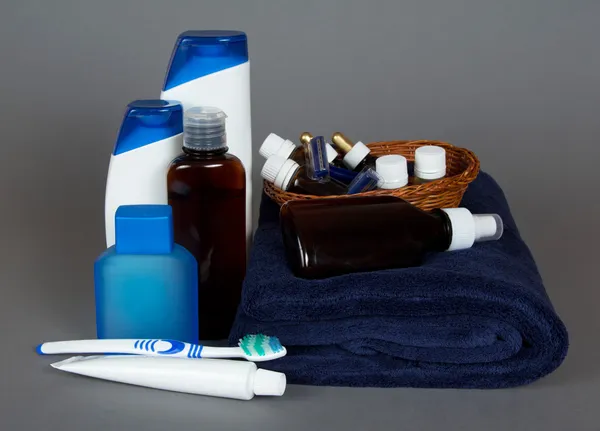 tuvalet aksesuarları, havlu, diş fırçası ve diş macunu, gri bir arka plan üzerinde