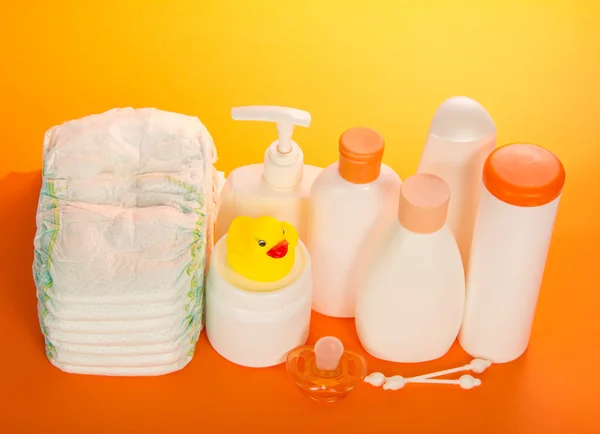 Conjunto para cuidar da criança e fraldas na laranja — Fotografia de Stock