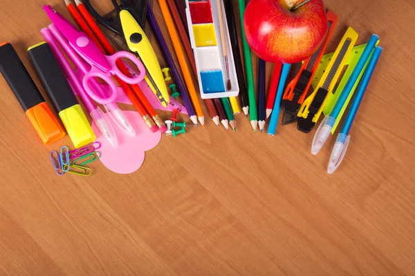 Set of bright office tools, a paints and apple on a table — Stock Photo, Image