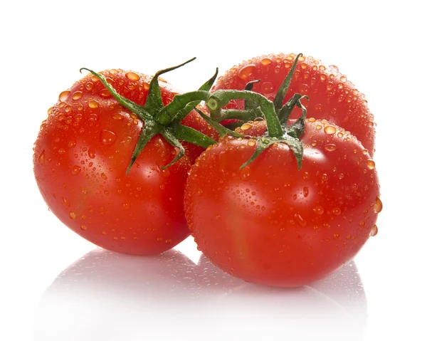 Three fresh tomatoes with green leaves isolated on white — Stock Photo, Image