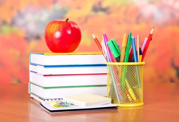 Libros, manzanas, lápices y tiradores en un soporte y tarjetas vacías, sobre una mesa — Foto de Stock