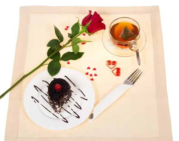 Gâteau au chocolat, thé chaud et rose rouge sur un chiffon décoré de coeurs à la Saint Valentin — Photo