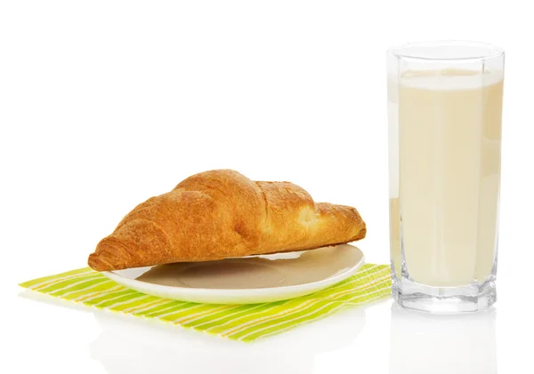 Glas melk en croissant op een servet, geïsoleerd op wit — Stockfoto