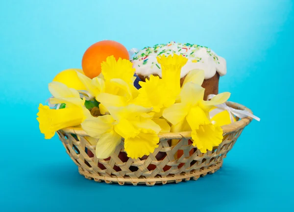 Bolo de Páscoa, ovos e flores em uma cesta, em um fundo azul — Fotografia de Stock