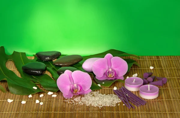 Flores de orquídea, set para Spa en un paño de bambú. Fondo verde — Foto de Stock
