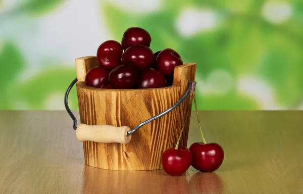 Montón de cerezas dulces maduras que cayeron de un cubo, sobre una mesa —  Fotos de Stock