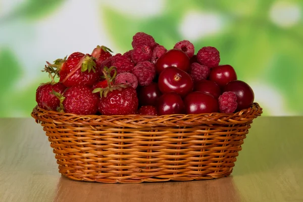 ラズベリーとテーブルの上のバスケットに甘いチェリーのいちごの熟した香り果実 — ストック写真