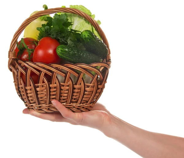 La mano femminile tiene un cesto con le verdure, isolato su bianco — Foto Stock