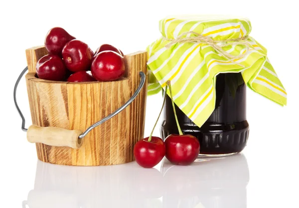 Jar of jam a wooden bucket with sweet cherries and two cherries near — Stock Photo, Image