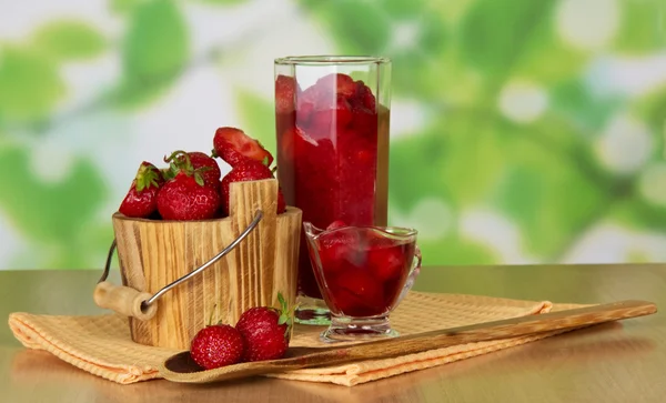 Strawberry in a bucket and in a glass, berries in a bowl and a spoon, napkins on a table — Stock Photo, Image