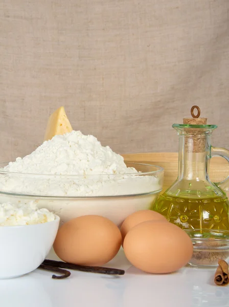 Cottage cheese, eggs, sunflower oil, flour against a canvas — Stock Photo, Image
