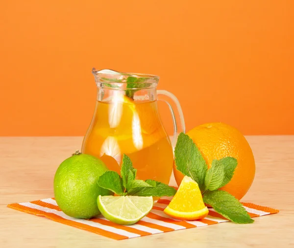 Napój pomarańczowy, owoców cytrusowych, mięty i paski serwetki na stół — Zdjęcie stockowe