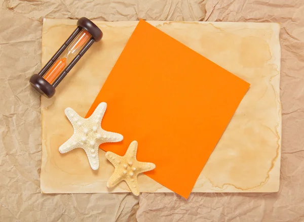Gamla papper, två starfishes, timglas och orange kort — Stockfoto