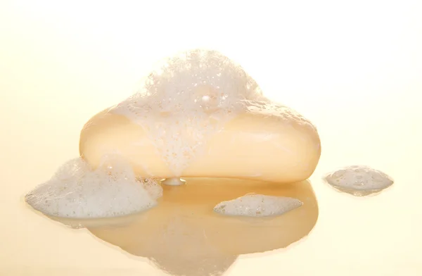 Natte zeep met schuim geïsoleerd op wit — Stockfoto