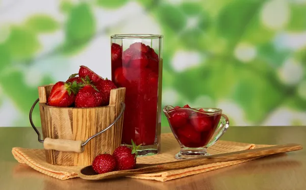 Strawberry in a bucket and in a glass, berries in a bowl and a spoon, napkins on a table — Stock Photo, Image