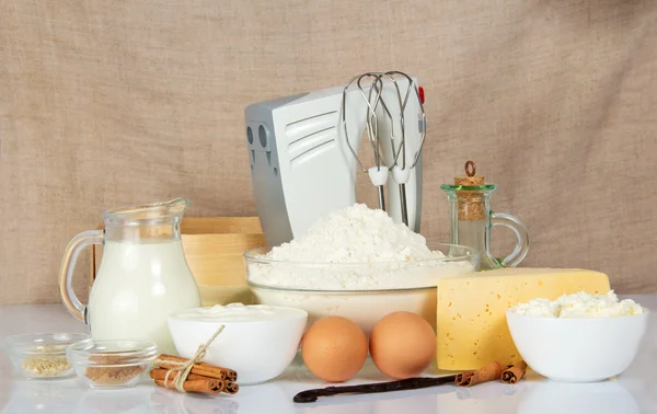 Mixer, zeef en producten voor het bakken, tegen een doek — Stockfoto