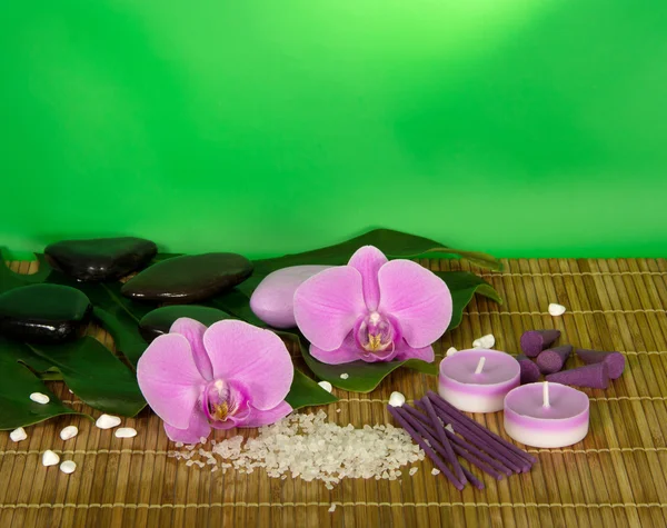 Orchid flowers, set for Spa on a bamboo cloth. Green background — Stock Photo, Image