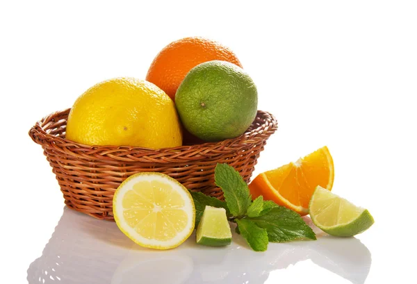 Citrus in a wicker basket, slices of fruit near a basket, mint — Stock Photo, Image