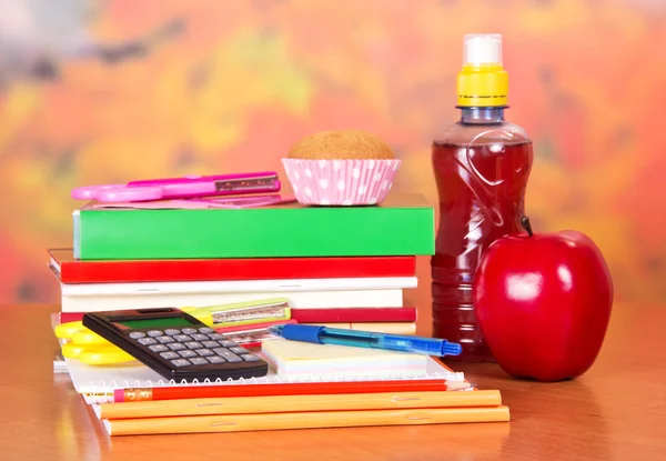 Un conjunto de accesorios escolares, botella con bebida, pastel y manzana —  Fotos de Stock