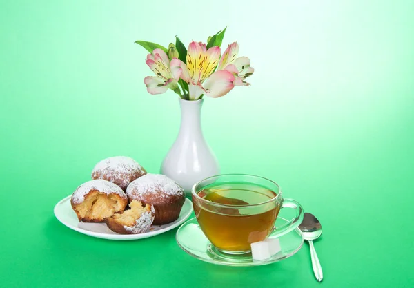 Tea with cupcakes for a breakfast, on a green background — Stock Photo, Image