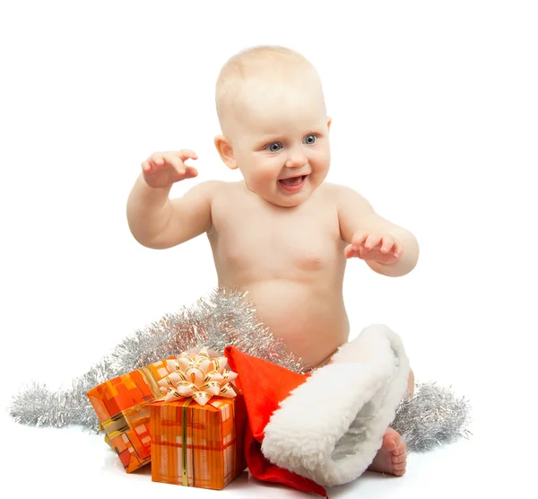 Joyeux bébé avec tinsel d'argent de Noël, chapeau rouge du Père Noël et boîtes-cadeaux lumineuses isolées sur blanc — Photo