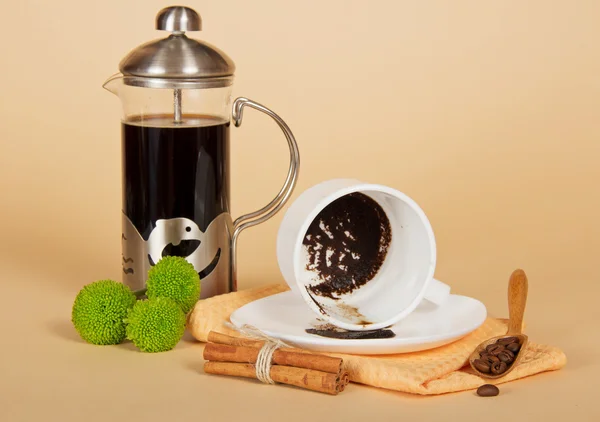 Coffee pot, the overturned cup, cinnamon, spoon, chrysanthemum and napkin — Stock Photo, Image
