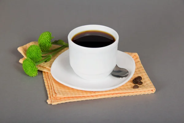 Kopje koffie, schotel, lepel, servet en groen chrysanthemum, op een grijze achtergrond — Stockfoto