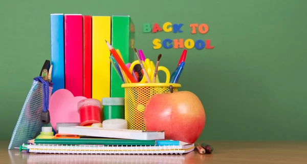 Pila di libri di testo, un caso della matita, una serie di scrittura-materiali e mela — Foto Stock