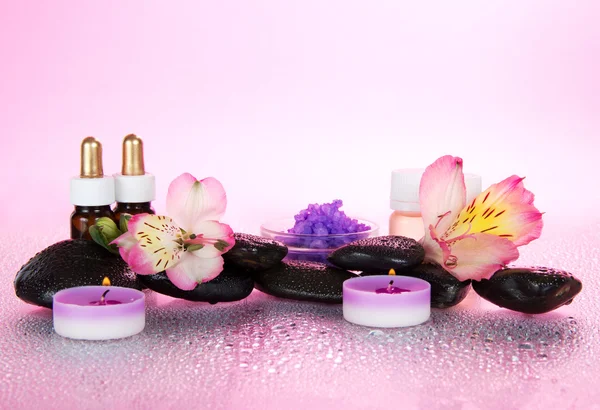 El juego de los aceites perfumados, la sal, las velas, las piedras, el hilo dental, sobre el fondo rosado —  Fotos de Stock