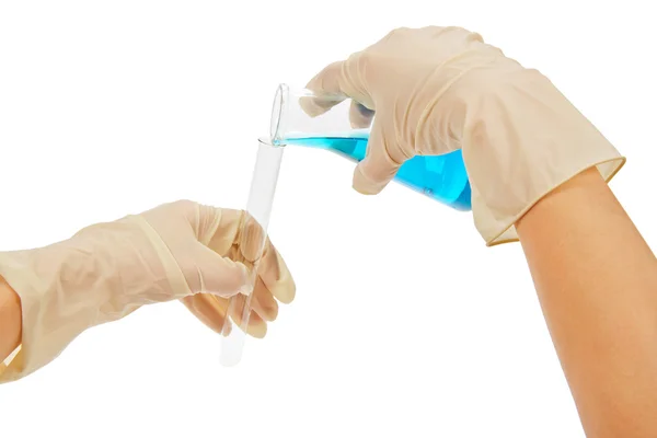 Vetreria da laboratorio con liquido blu, mani in guanti isolate su bianco — Foto Stock
