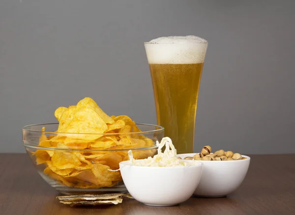 Glass of fresh light beer with foam and bubbles and the snack — Stock Photo, Image